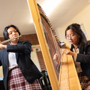 students playing a harp and a flute