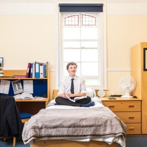 boy sat studying on his bed