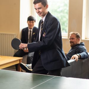 student hitting a ball as his plays table tennis