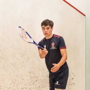 student holding squash racquet
