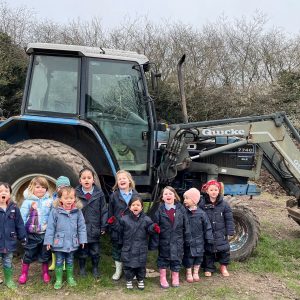 children stood in front of a tractor