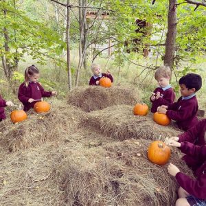 children hammering pumpkins