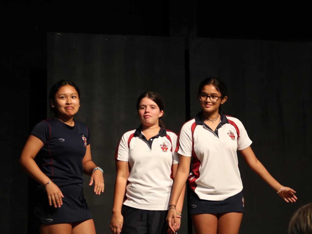 Three school girls on stage in sports wear