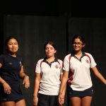 Three school girls on stage in sports wear