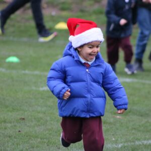 child running in santa hat