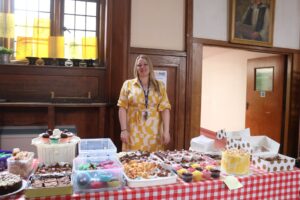 Teacher standing behind table at cake sale