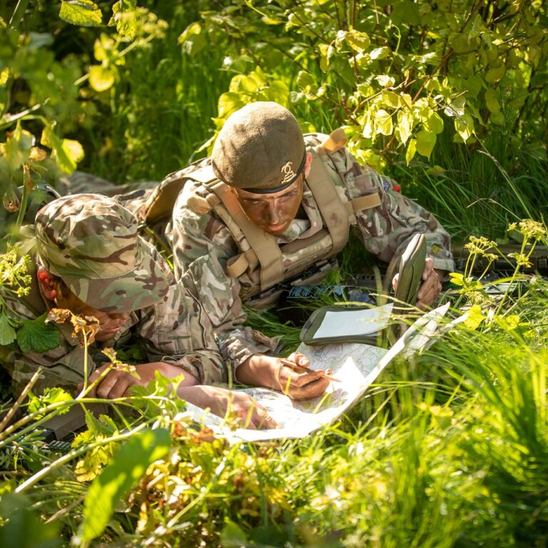 two boys camouflaged reading a map