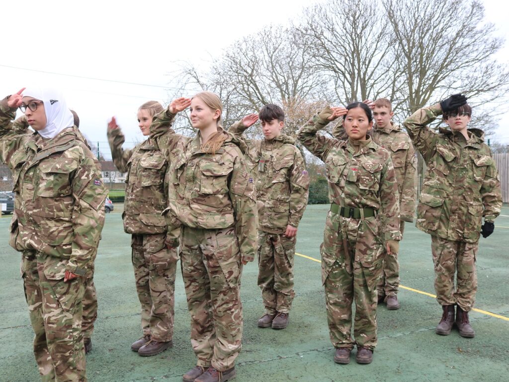 students saluting in cadet uniform